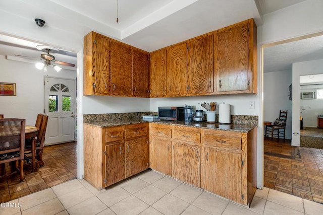 kitchen with stainless steel microwave, ceiling fan, and brown cabinetry
