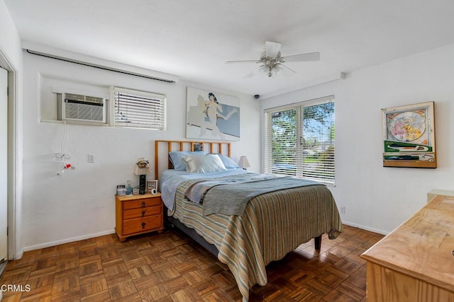 bedroom featuring an AC wall unit, baseboards, and ceiling fan