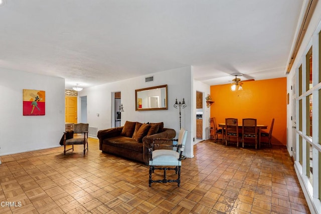 living room featuring a ceiling fan and visible vents