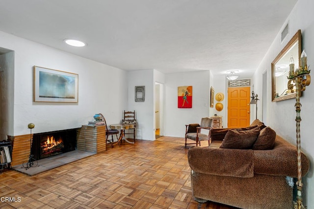 living area featuring a lit fireplace and visible vents