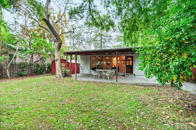 rear view of property featuring fence, a chimney, a lawn, and a deck
