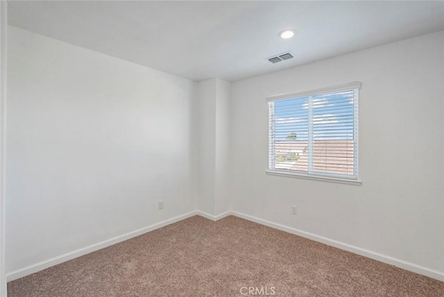 spare room featuring baseboards, carpet, recessed lighting, and visible vents