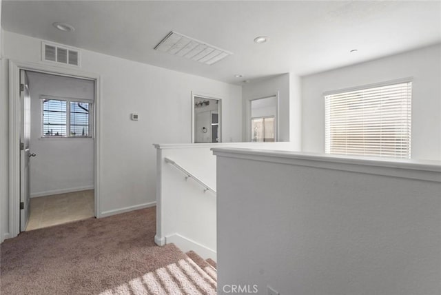 interior space with carpet, recessed lighting, baseboards, an upstairs landing, and visible vents