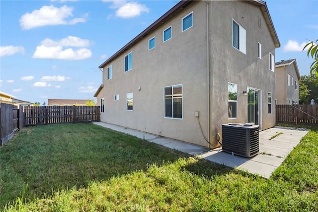 back of house featuring a lawn, central air condition unit, a fenced backyard, a patio, and stucco siding
