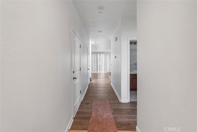hall featuring baseboards and wood finished floors