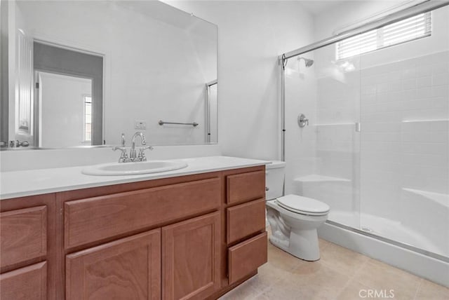bathroom featuring vanity, toilet, tile patterned floors, and a stall shower