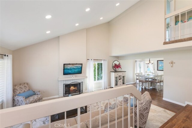 1452 Granada, Corona, CA 92878 - living area with high vaulted ceiling, a fireplace, wood finished floors, baseboards, and a chandelier