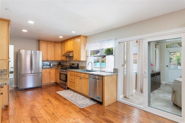 1452 Granada, Corona, CA 92878 - kitchen featuring stainless steel appliances, under cabinet range hood, a sink, light wood-style floors, and light stone countertops