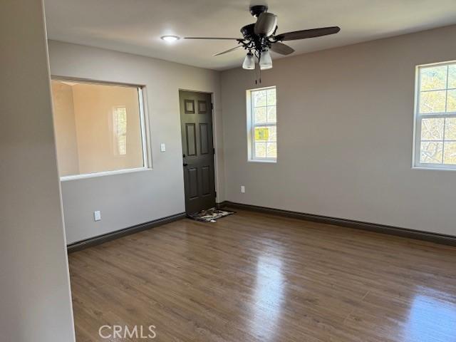 373 Davos Dr, Crestline, CA 92325 - unfurnished room with baseboards, ceiling fan, plenty of natural light, and wood finished floors