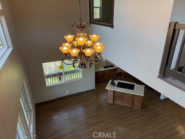 373 Davos Dr, Crestline, CA 92325 - interior space with baseboards, a high ceiling, dark wood-style floors, and a notable chandelier