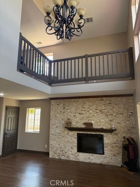 373 Davos Dr, Crestline, CA 92325 - unfurnished living room featuring a high ceiling, a chandelier, a glass covered fireplace, baseboards, and wood finished floors