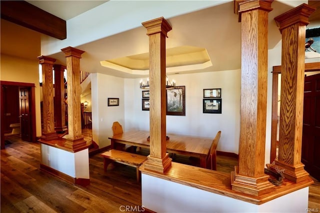 interior space featuring decorative columns and wood finished floors