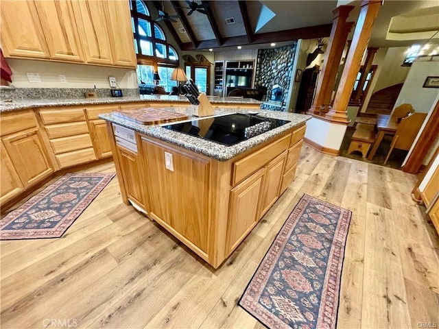 kitchen with light brown cabinetry, decorative columns, black electric stovetop, and light wood-type flooring