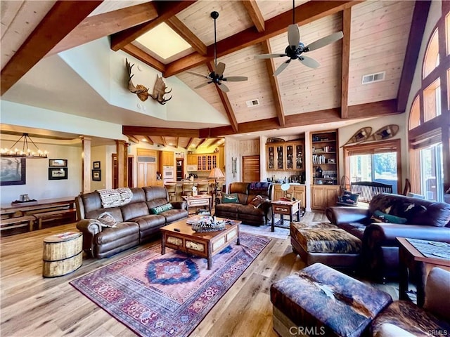living room featuring high vaulted ceiling, decorative columns, wood finished floors, and visible vents