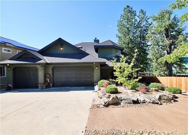 view of front of house featuring fence, a shingled roof, driveway, and a garage
