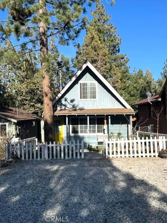 view of front facade with covered porch and a fenced front yard