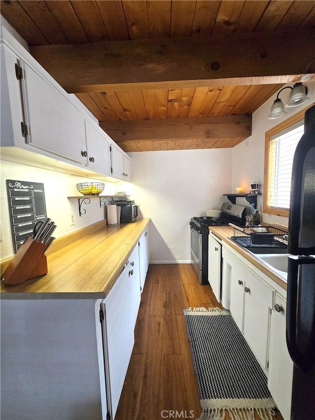 143 Cedar Ln, Sugarloaf, CA 92386 - kitchen with wood ceiling, stainless steel range with gas stovetop, freestanding refrigerator, beamed ceiling, and white cabinets