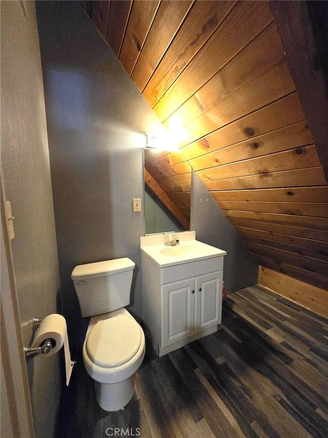half bathroom featuring wood ceiling, vaulted ceiling, wood finished floors, vanity, and toilet