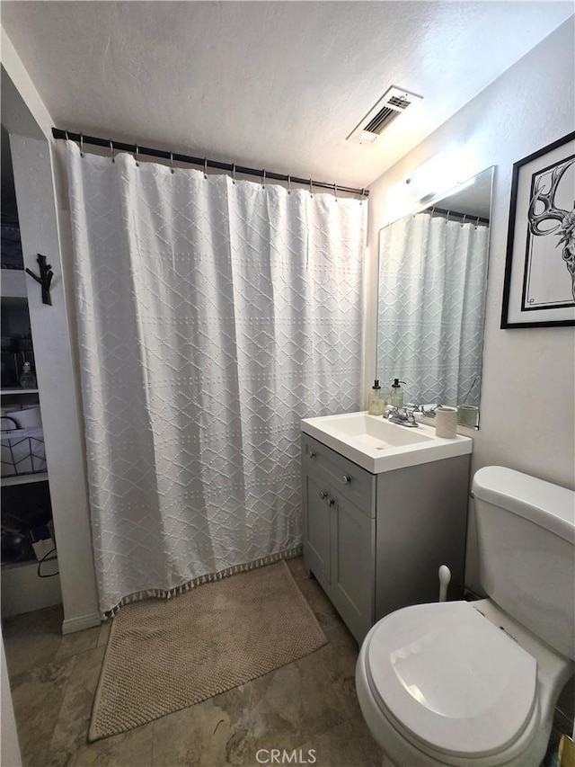 full bathroom with vanity, a shower with shower curtain, toilet, and visible vents