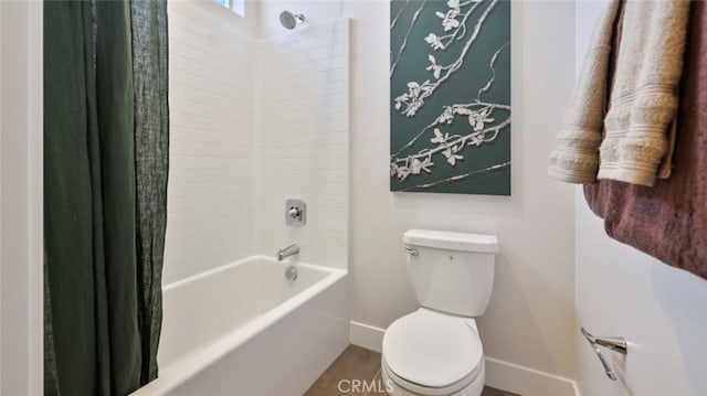 full bathroom featuring toilet, baseboards, and shower / tub combo