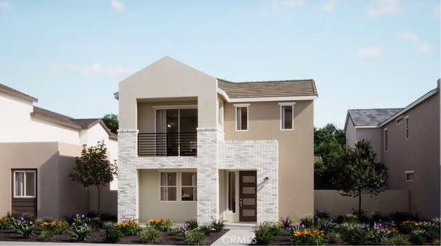 contemporary home with brick siding, a balcony, and stucco siding