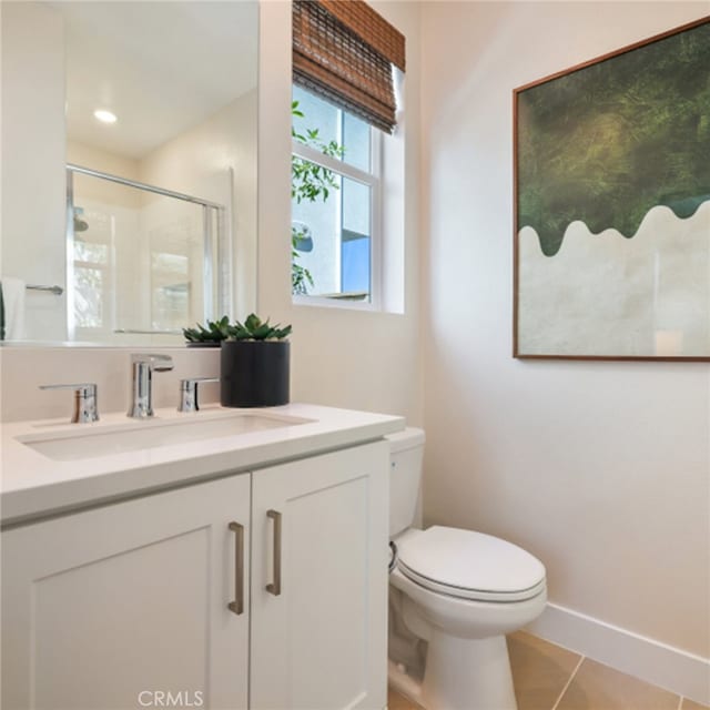 bathroom with tile patterned flooring, a shower stall, vanity, baseboards, and toilet