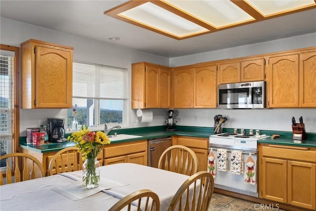 kitchen with dark countertops, appliances with stainless steel finishes, and a sink