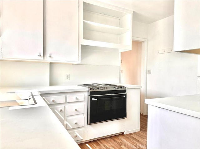 kitchen featuring light countertops, white cabinetry, and gas range