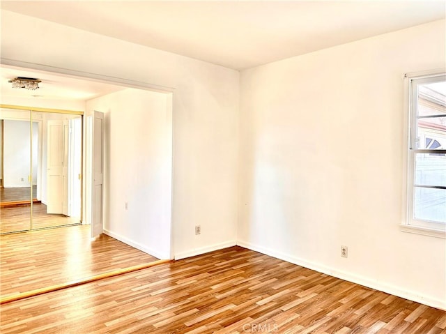 unfurnished room featuring baseboards and light wood-style flooring