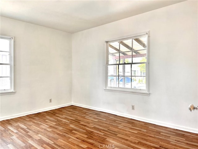 empty room featuring baseboards and wood finished floors