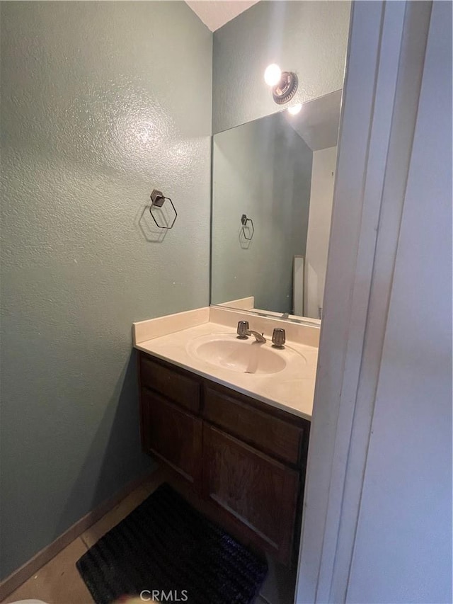 bathroom featuring vanity, a textured wall, and tile patterned floors