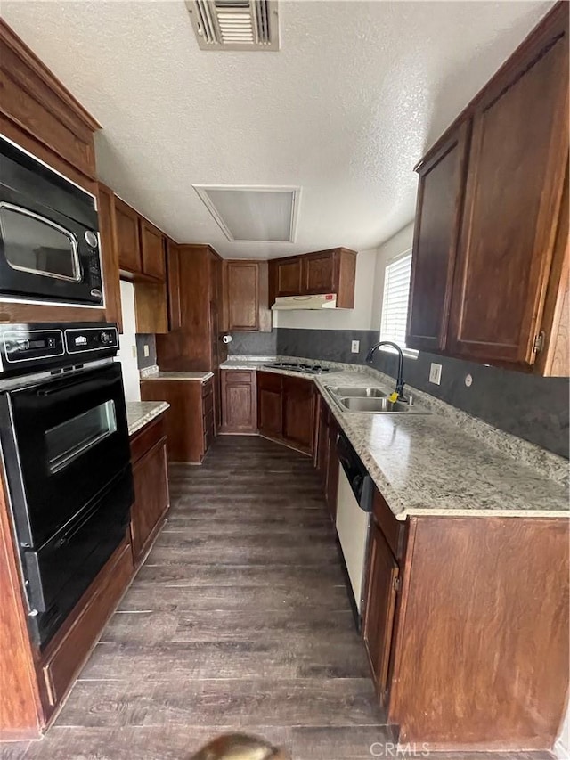 kitchen with visible vents, dark wood-style flooring, a textured ceiling, a sink, and black appliances