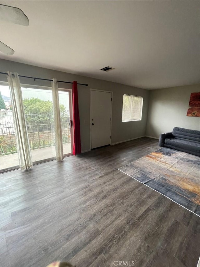 unfurnished living room featuring visible vents and wood finished floors