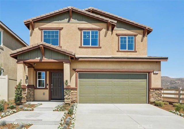 craftsman inspired home featuring fence, board and batten siding, an attached garage, and stone siding