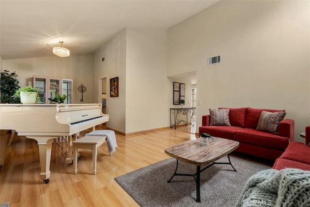 6192 Sierra Siena Rd, Irvine, CA 92603 - living area featuring visible vents, baseboards, wood finished floors, and high vaulted ceiling