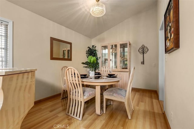 6192 Sierra Siena Rd, Irvine, CA 92603 - dining area featuring baseboards, light wood finished floors, a chandelier, and vaulted ceiling