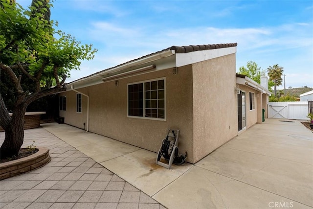 6192 Sierra Siena Rd, Irvine, CA 92603 - view of home's exterior featuring a patio, a gate, stucco siding, and fence