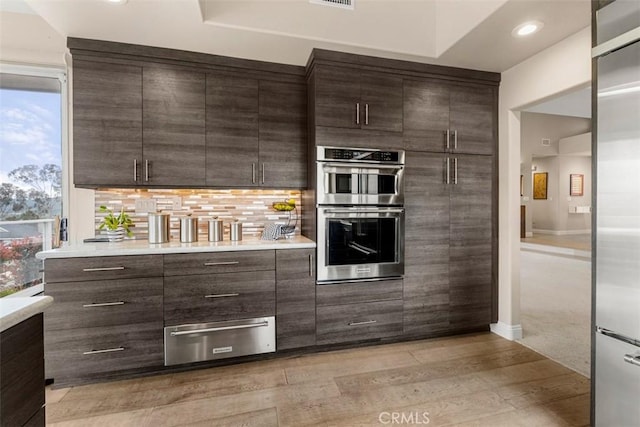20 Delphinus Unit 20, Irvine, CA 92603 - kitchen featuring dark brown cabinetry, appliances with stainless steel finishes, modern cabinets, light countertops, and a warming drawer