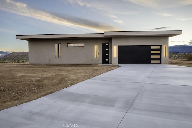 view of front of home featuring a garage, stucco siding, and driveway