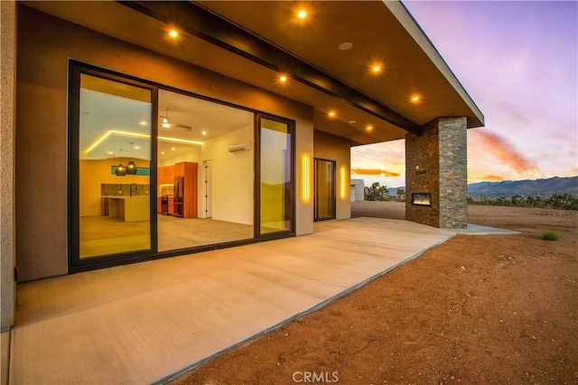 exterior space with a patio, a mountain view, and stucco siding