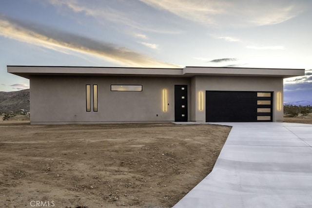 view of front of property featuring an attached garage, driveway, and stucco siding