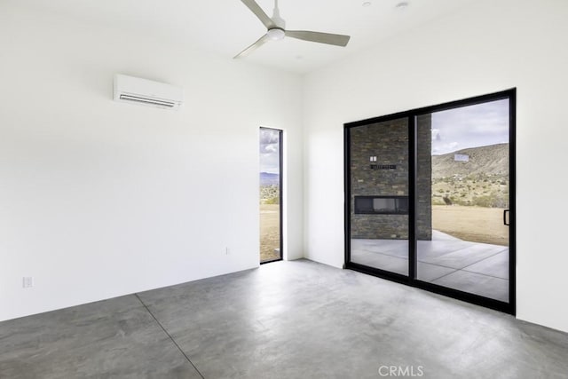 unfurnished room with plenty of natural light, a wall mounted air conditioner, concrete floors, and a ceiling fan