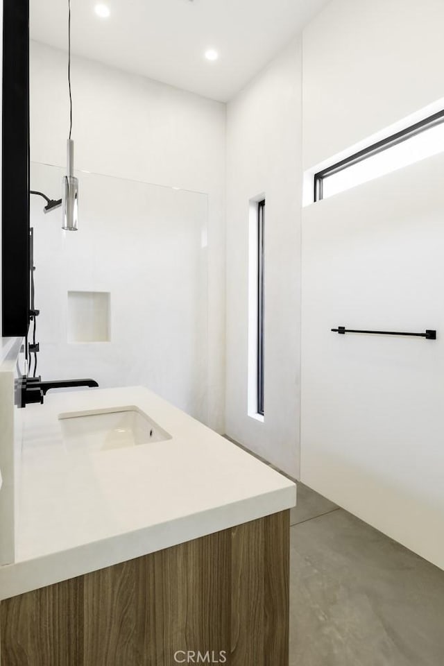 bathroom with finished concrete floors, recessed lighting, and vanity