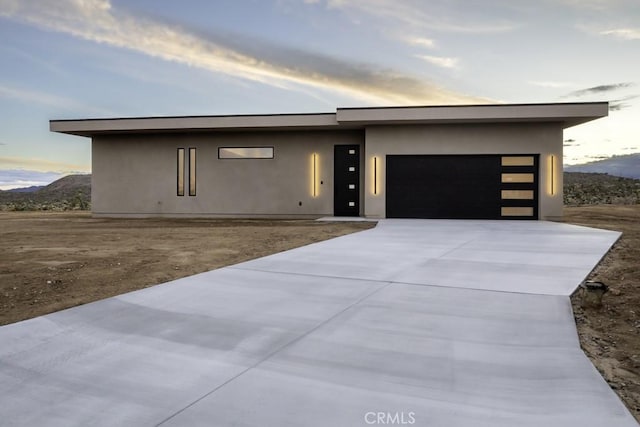 contemporary house with concrete driveway, an attached garage, and stucco siding