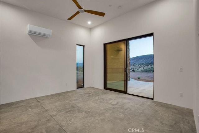 empty room with ceiling fan, a wall unit AC, and concrete flooring