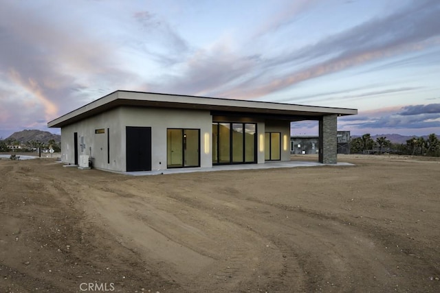 exterior space with a mountain view and stucco siding