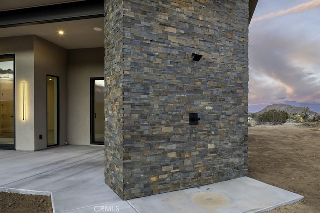 exterior entry at dusk with a mountain view and stucco siding