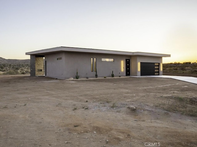 modern home with a garage, stucco siding, and driveway
