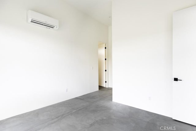 spare room with finished concrete floors and a wall mounted AC