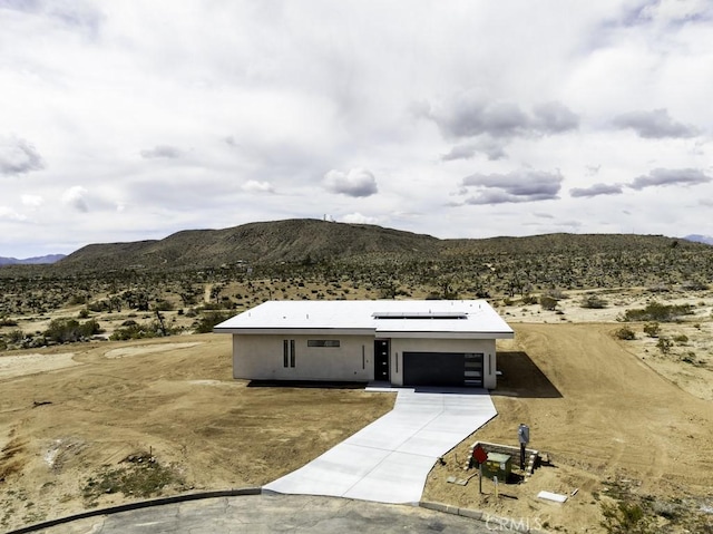view of front of home featuring a garage, a mountain view, and a desert view
